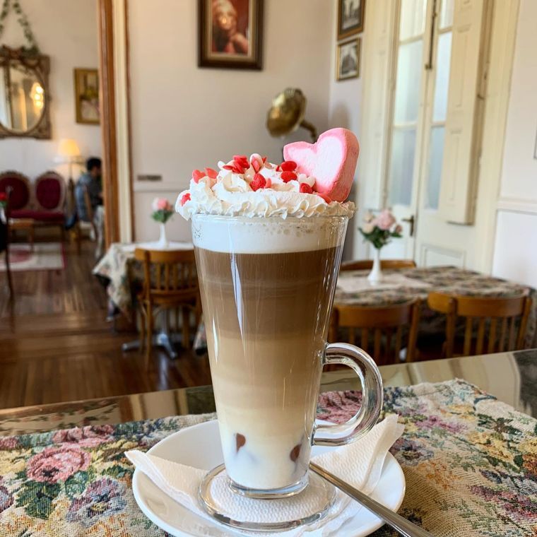 Café Cupido en vaso alto con crema chantilly y corazones.