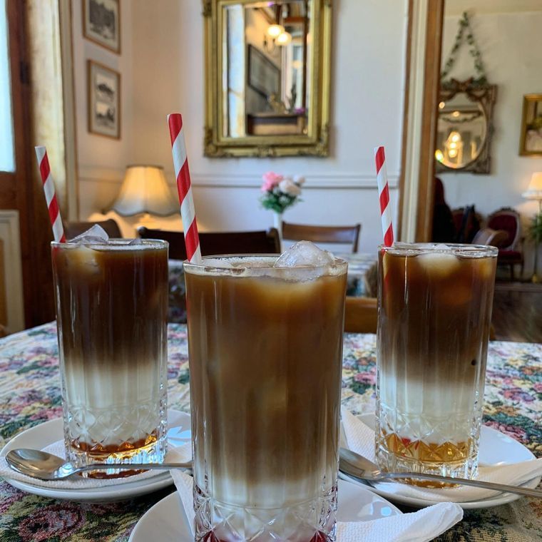 Dos cafés fríos con hielo y bombilla sobre la mesa del salón.
