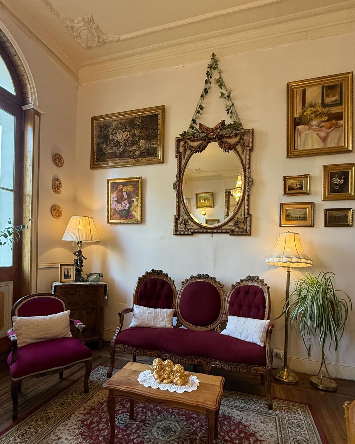 Salón de Café Cupido: sillón de terciopelo, espejo dorado y cuadros antiguos.